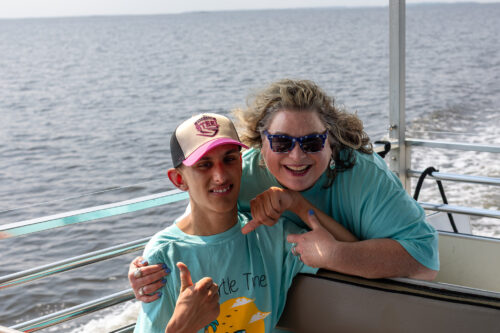 Two people on a boat smile at the camera.