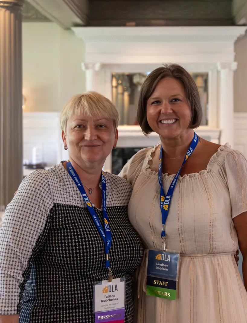 thumbnail image - Two women smile at the camera in an elegant dining room.